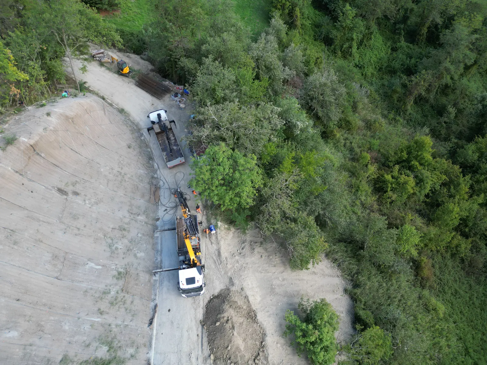 Mezzi e operatori al lavoro al piede della scarpata