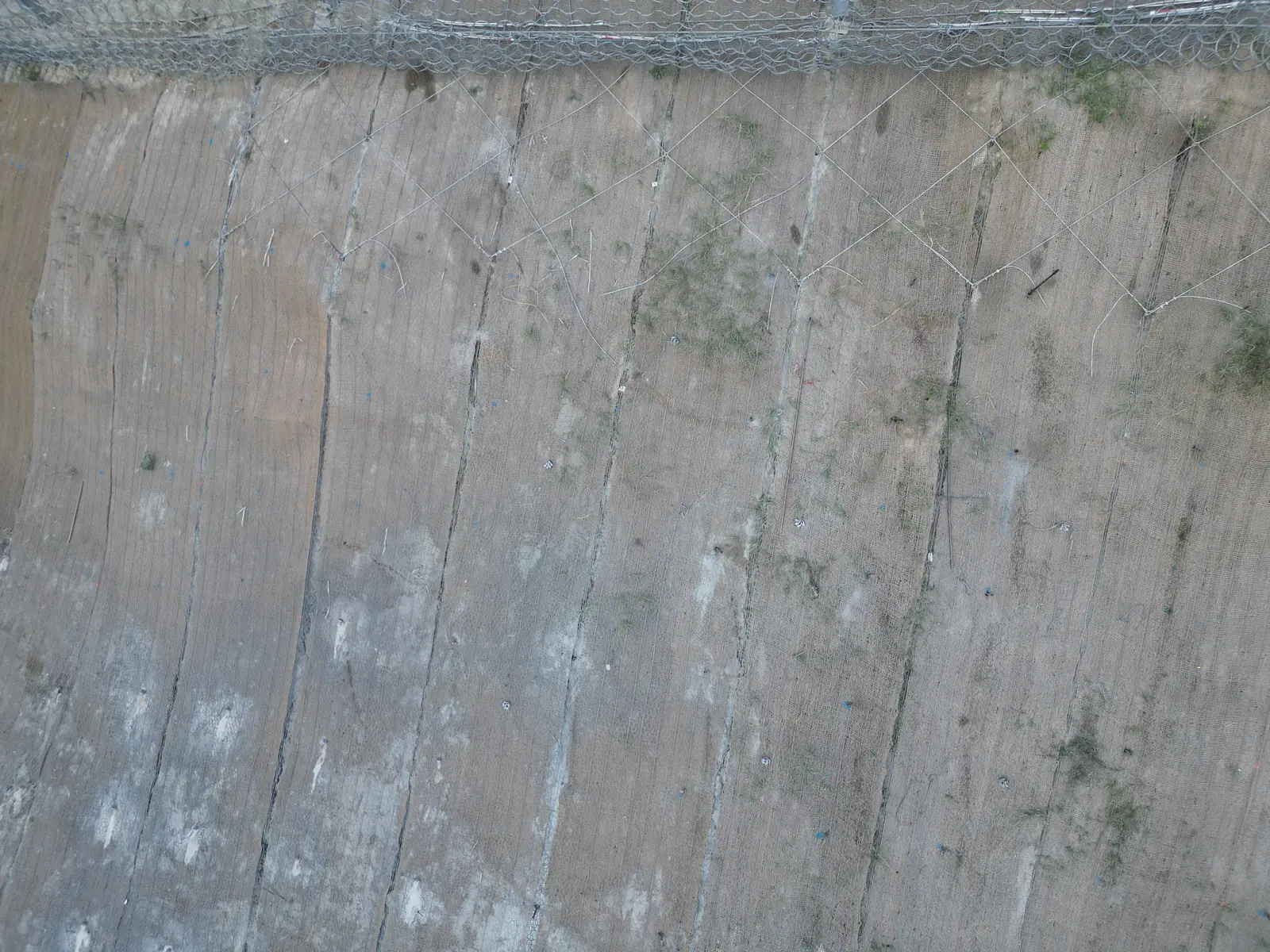 Scarpata rivestita con rete metallica in aderenza e chiodature vista dal drone