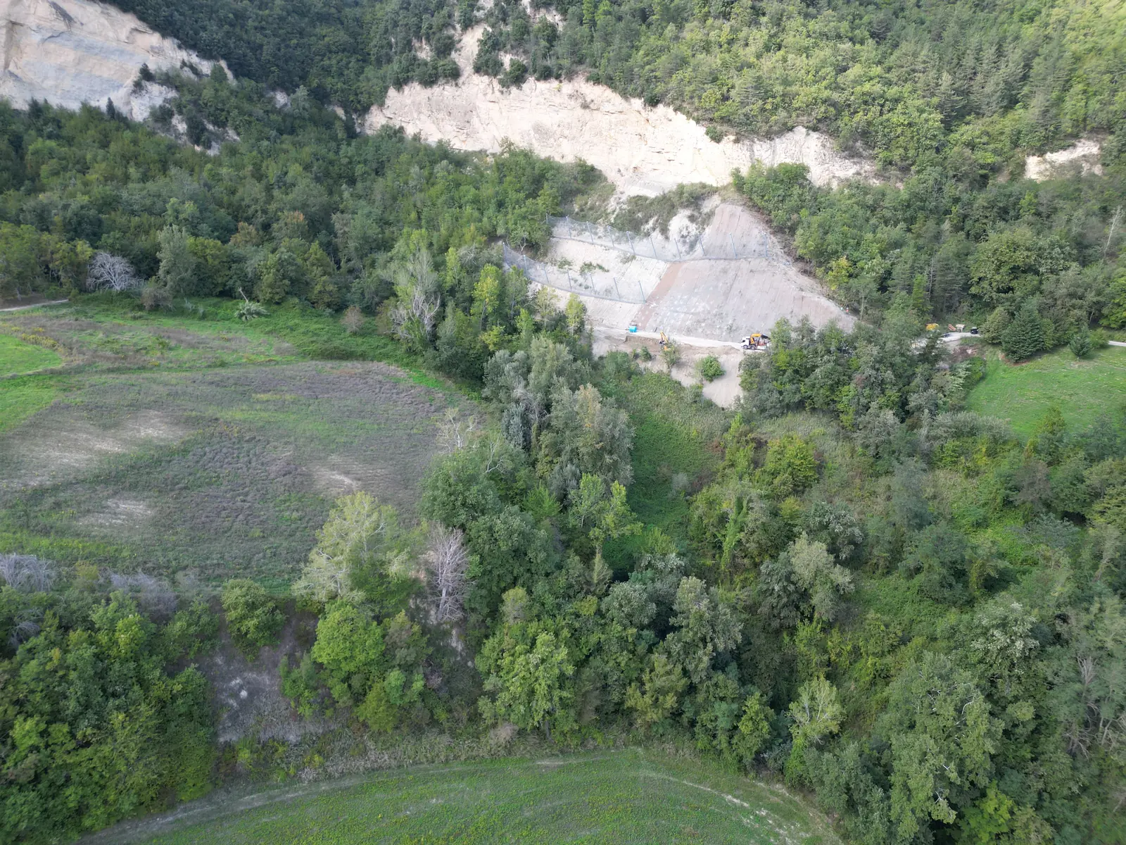 Versante in consolidamento visto dalla valle, tra boschi e prati dell’Appennino